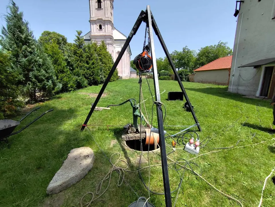 Trojnožka nad kopanou studňou pri čistení